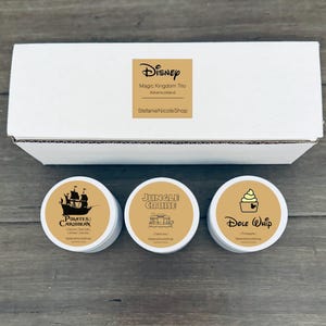 May include: Three round, brown and white labels with Disney park scents. The labels are labeled "Pirates of the Caribbean", "Jungle Cruise", and "Dole Whip".