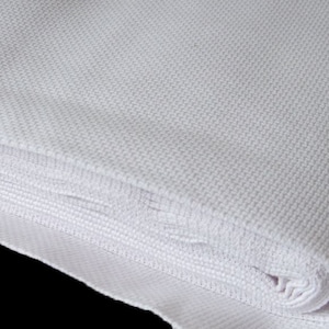 May include: A white Aida cloth fabric, folded and rolled up, for cross stitch and needlepoint projects.