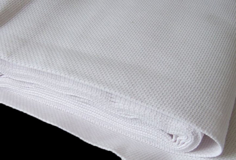 May include: A white Aida cloth fabric, folded and rolled up, for cross stitch and needlepoint projects.