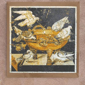 May include: A mosaic artwork featuring a golden bowl with four doves perched on the rim. The doves are white with grey markings and are arranged symmetrically around the bowl. The bowl is decorated with intricate floral patterns and sits on a black background.