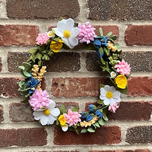 Sun salutations with bluebells, daisies, yellow roses and pink carnations.