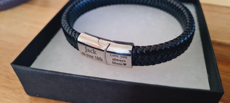 May include: Black braided leather bracelet with a silver clasp, presented in a black gift box. The clasp is engraved with the words "Jack on your 18th" and "Love you always Mum".