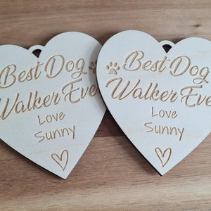 Puede incluir: Dos adornos de madera blanca en forma de coraz&oacute;n con el texto "Best Dog Walker Ever" y "Love Sunny" en cada uno.