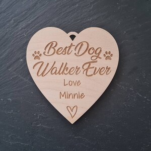 Puede incluir: Una placa de madera en forma de coraz&oacute;n con el texto "Best Dog Walker Ever" y "Love Minnie" con un peque&ntilde;o s&iacute;mbolo de coraz&oacute;n.