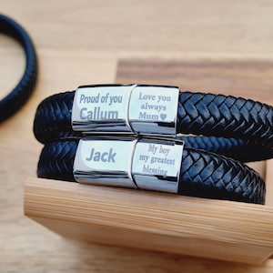 May include: Black braided leather bracelets with silver clasps. One bracelet is engraved with "Proud of you Callum" and "Love you always Mum". The other is engraved with "Jack" and "My boy my greatest blessing".