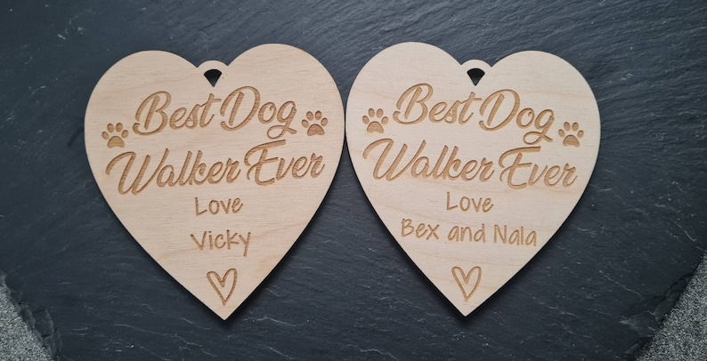 Puede incluir: Dos letreros de madera en forma de coraz&oacute;n con el texto "Best Dog Walker Ever" y los nombres "Vicky" y "Bex and Nala".