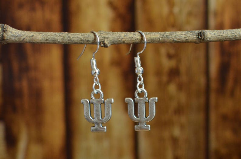 May include: A pair of silver earrings with a Greek letter psi charm hanging from each earring.