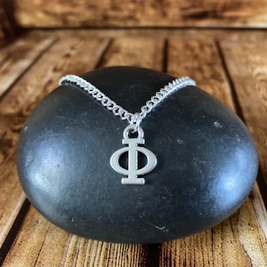 Può includere: Una collana con catena d'argento con un ciondolo d'argento a forma della lettera greca Phi.