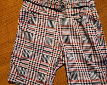 May include: Red, white, and black plaid shorts with a belt and a silver buckle.