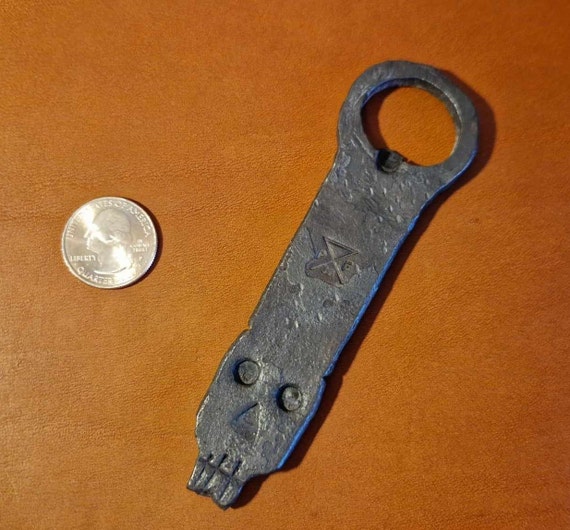 A hammer-forged skull face on a steel opener — dark, tactile, and handmade enough that every one looks slightly different.