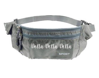 May include: Gray fanny pack with two zippered compartments and an adjustable strap. The text "Delta Delta Delta" and "SPORT" are printed on the front. The bag is made of a textured, possibly water-resistant material.