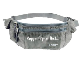 May include: Gray fanny pack with two zippered compartments and an adjustable strap. The text "Kappa Alpha Theta" is printed in white, with "SPORT" below it. The bag is designed for carrying essentials during sports or outdoor activities.
