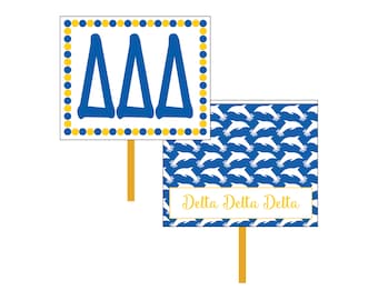 May include: Two signs with a blue and white dolphin pattern and the text "Delta Delta Delta" on one sign and the Greek letters "ΔΔΔ" on the other sign.