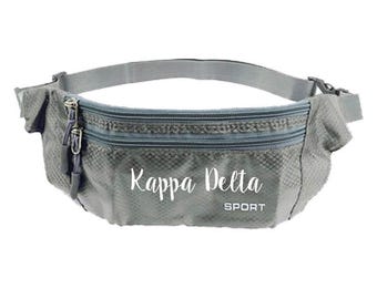May include: Gray fanny pack with the text "Kappa Delta SPORT" in white. The pack has two zippered compartments and an adjustable strap. The material has a subtle diamond pattern.