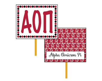 May include: A red and white sign with black polka dots and the letters "AOP" in red. Below the sign is a smaller red sign with a white panda bear pattern and the text "Alpha Omicron Pi".