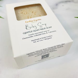 Puede incluir: Una caja blanca de jab&oacute;n para beb&eacute;s Carolina Organics. La caja tiene una ventana que muestra el jab&oacute;n en su interior. El jab&oacute;n no tiene perfume y est&aacute; hecho con leche de cabra, manzanilla, avena coloidal y cal&eacute;ndula. Peso neto 142 gramos.