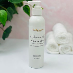 May include: White bottle of Hyaluronic Acid Anti-Aging Lotion with a pump dispenser. The bottle is labeled with the text "Carolina Organics Soap Co." and "Scented in Cucumber Melon".
