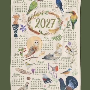 Può includere: Un canovaccio rettangolare bianco con un calendario del 2027 che presenta illustrazioni dipinte a mano di vari uccelli, tra cui un picchio verde, un barbagianni e un gallo cedrone, circondati da elementi botanici, piume e griglie mensili.