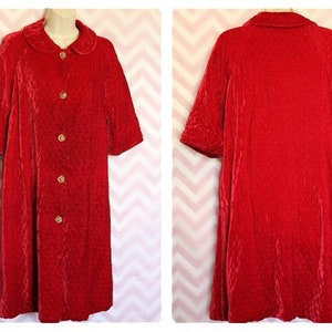 May include: A red velvet robe with a button-up front and a collar. The robe has a quilted texture and gold buttons.