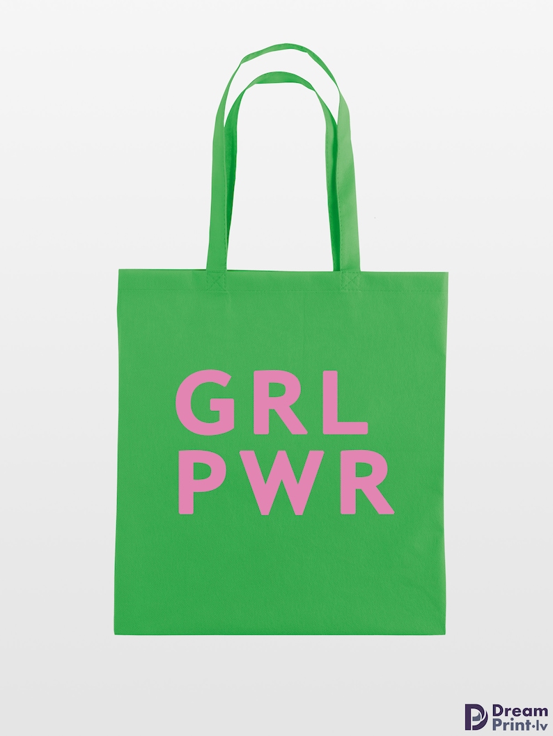 May include: A bright green tote bag with the pink text "GRL PWR" printed on the front. The bag has matching green handles and is made of a sturdy fabric, perfect for carrying groceries or other items.