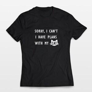 May include: Black t-shirt with white text that reads "Sorry, I can't I have plans with my cat" and a white cat face graphic.