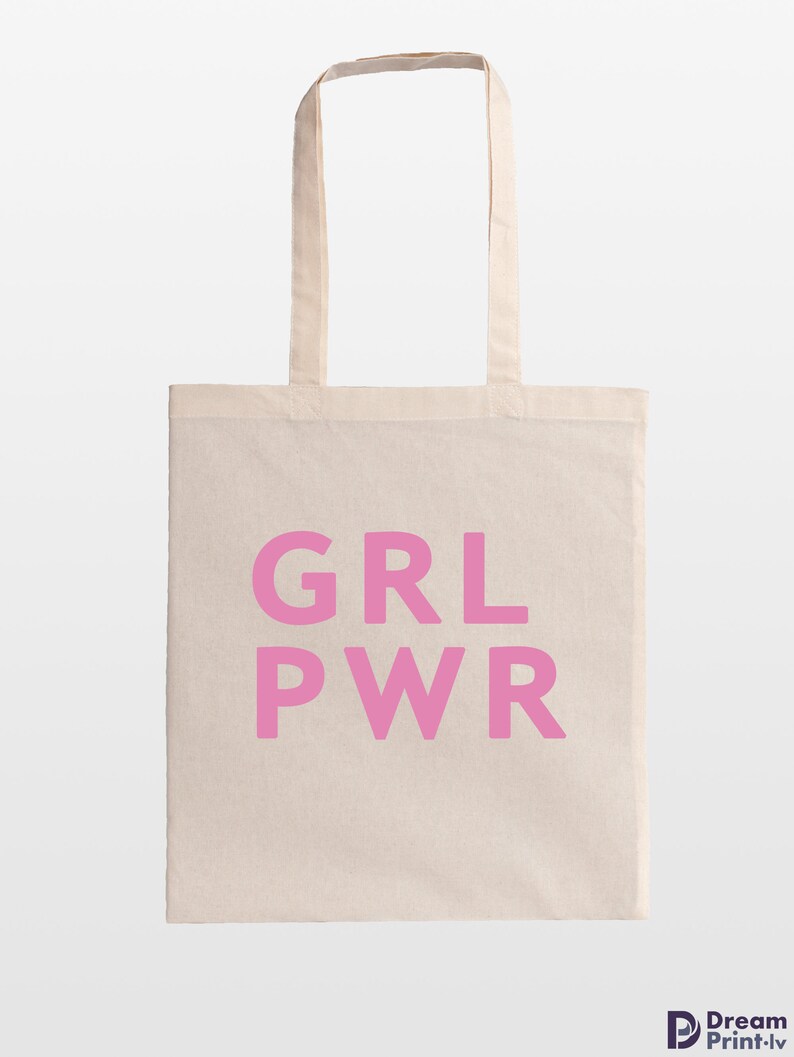 May include: A beige tote bag with the pink text "GRL PWR" printed on the front. The bag has two beige handles and is made of a canvas-like material. The bag is designed for carrying items.