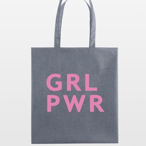 May include: Gray tote bag with the pink text "GRL PWR" printed on the front. The bag has two handles and is made of a sturdy fabric. The background is plain white.