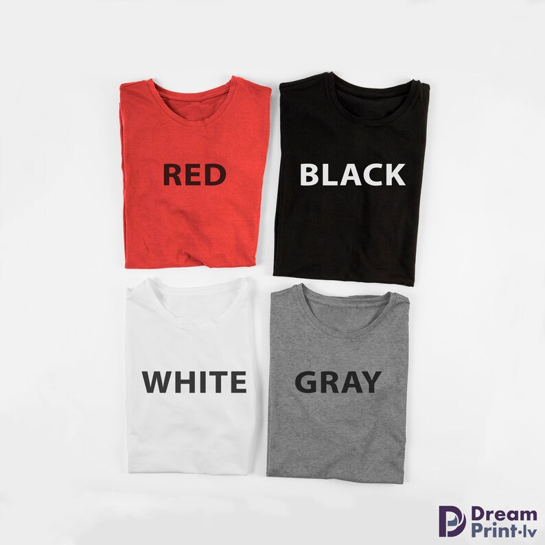 May include: Four folded t-shirts in different colors: red, black, white, and gray. Each shirt has the color name printed on the front in white.