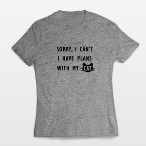 May include: A heather grey t-shirt with the text "Sorry, I can't I have plans with my cat" and a black silhouette of a cat with the word "cat" above it.