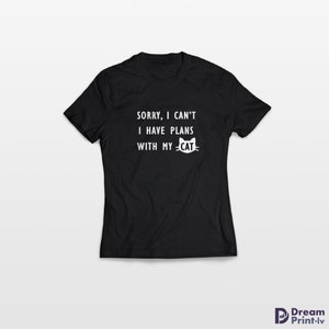 May include: Black t-shirt with white text that reads "Sorry, I can't I have plans with my -CAT-" and a white cat face graphic.