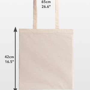 May include: A beige tote bag with dimensions of 15.0" wide, 16.5" tall, and 26.6" handle length. The bag has a rectangular shape and two handles. The text "Handles 26.6"" is visible on the image.