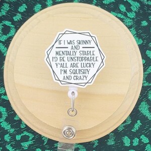 May include: A wooden badge holder with a green leopard print background and a light wood badge reel. The badge reel has a sticker that reads "IF I WAS SKINNY AND MENTALLY STABLE I'D BE UNSTOPPABLE Y'ALL ARE LUCKY I'M SQUISHY AND CRAZY". The words "wordspapermagic" are at the bottom.