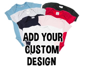 May include: A stack of six baby onesies in different colors, including light blue, gray, navy blue, pink, red, and white. The onesies are all folded and stacked on top of each other. The text "ADD YOUR CUSTOM DESIGN" is printed in black on the white onesie.