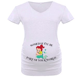 Op de afbeelding: Witte zwangerschaps-t-shirt met een V-hals. De shirt heeft een afbeelding van Ariel uit De Kleine Zeemeermin die Botje omhelst, met de tekst "Someday I'll be part of your world" in zwart.