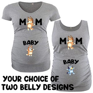 May include: Two gray maternity shirts with a cartoon dog design. The top shirt has a short sleeve and says "MOM" with a dog above the word. The bottom shirt has a tank top style and says "MOM" with a dog above the word. Both shirts have a smaller dog design below the word "BABY".