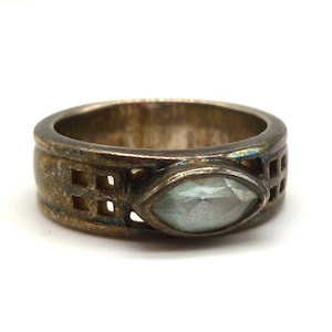 May include: A silver ring with a clear, faceted gemstone set in a geometric design.
