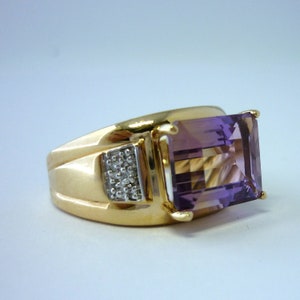 May include: A gold ring featuring a large, faceted amethyst gemstone and smaller diamonds set into the band.