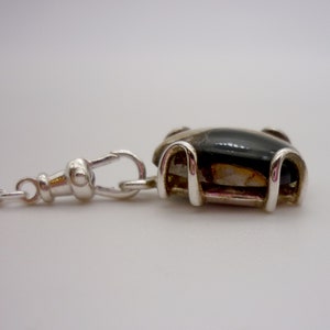 May include: A silver chain with a silver fob attached. The fob has a black and white agate stone set in a silver frame.