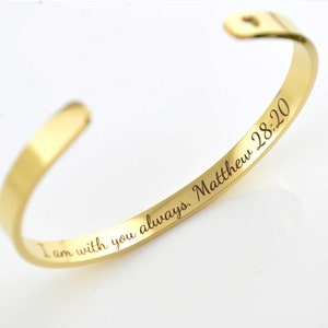 May include: Gold-toned bangle bracelet with an engraved inscription that reads "I am with you always. Matthew 28:20".