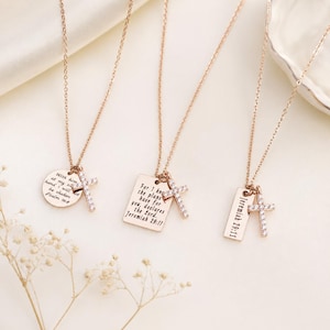 May include: Three rose gold-toned necklaces, each featuring a delicate chain, a small cross pendant encrusted with clear stones, and a metal charm. The charms are engraved with religious text: Psalm 16:8, Jeremiah 29:11, and Jeremiah 29:11.