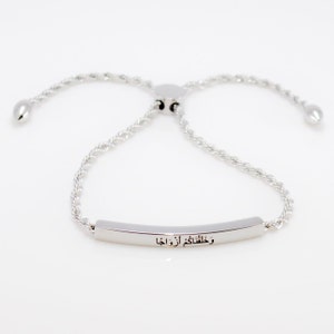 May include: A silver bracelet with a delicate rope chain and a bar charm engraved with the Arabic phrase "We thank you, our Lord".