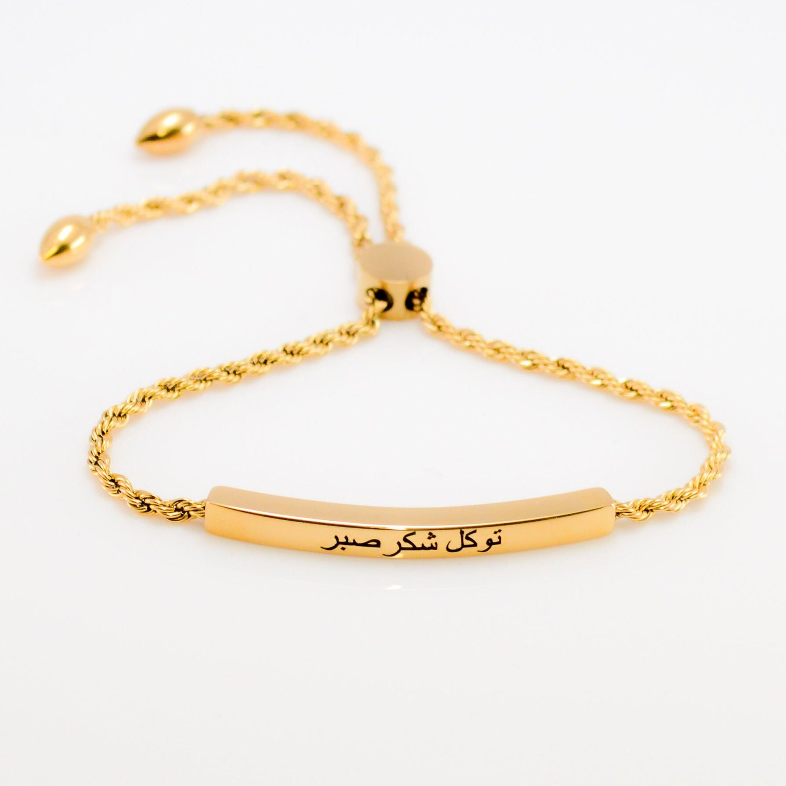 A gold sliding bracelet with Arabic writing on it