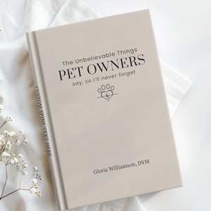May include: A beige hardcover book with black text that reads The Unbelievable Things PET OWNERS say, so I'll never forget, featuring a paw print heart icon and the name Gloria Williamson, DVM. The spine includes the text CUSTOM SPINE TEXT HERE.