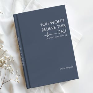 May include: A dark blue hardcover book with white text on the front cover that reads YOU WON'T BELIEVE THIS CALL ...stories I can't make up. Olivia Kingsley. The spine features the text CUSTOM SPINE TEXT HERE in a vertical orientation.