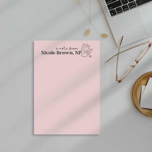 K&ouml;nnte beinhalten: Ein rosa Notizblock mit dem Text "a note from Nicole Brown, NP" und einer Zeichnung eines Klemmbretts und eines Stethoskops.