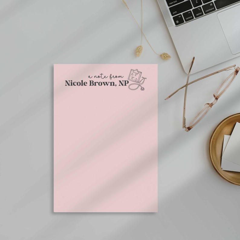 K&ouml;nnte beinhalten: Ein rosa Notizblock mit dem Text "a note from Nicole Brown, NP" und einer Zeichnung eines Klemmbretts und eines Stethoskops.