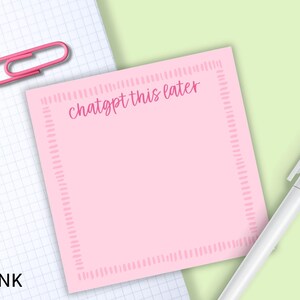 May include: A pink sticky note with the text "chatgpt this later" in a handwritten style. The note has a dotted border and is next to a white pen and a pink paper clip on a grid paper background.