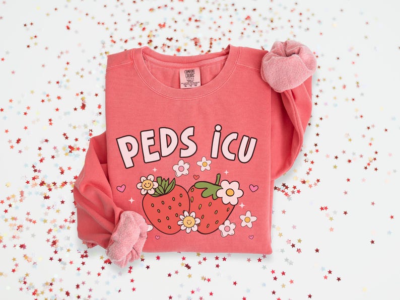 May include: A pink sweatshirt with the text "PEDS ICU" and a graphic of two strawberries with flowers.