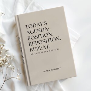 May include: A beige hardcover book with black text on the front cover reading: TODAY'S AGENDA: POSITION. REPOSITION. REPEAT. NOTES FROM AN X-RAY TECH and OLIVIA KINGSLEY. The spine features the text: CUSTOM SPINE TEXT HERE.