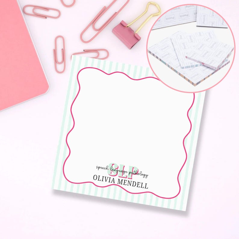 May include: A square notepad with a white background and a pink wavy border. The notepad has a light green and white striped pattern. The text "SLP speech language pathology OLIVIA MENDELL" is printed on the notepad. Pink paperclips and a pink binder clip are scattered around the notepad.